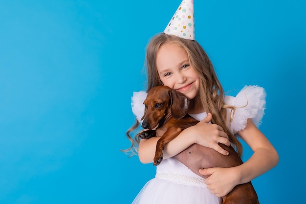 girl in a white fluffy elegant dress with a dachshund dog in her arms