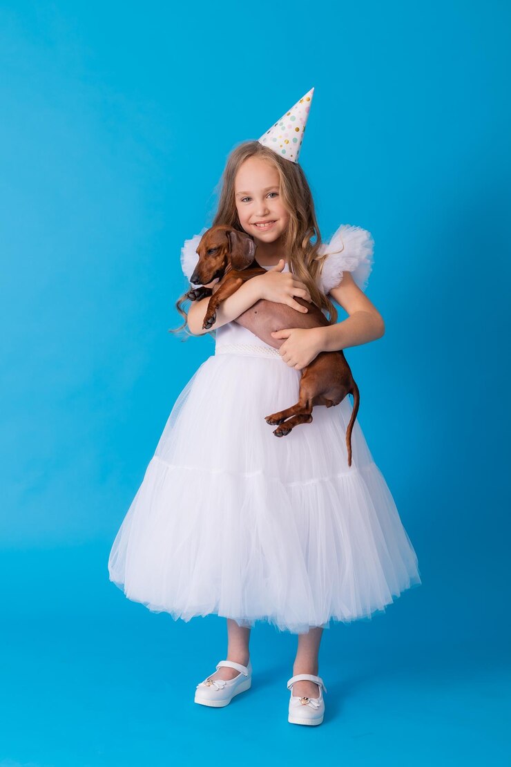 Photo girl in a white fluffy elegant dress with a dachshund dog in her arms