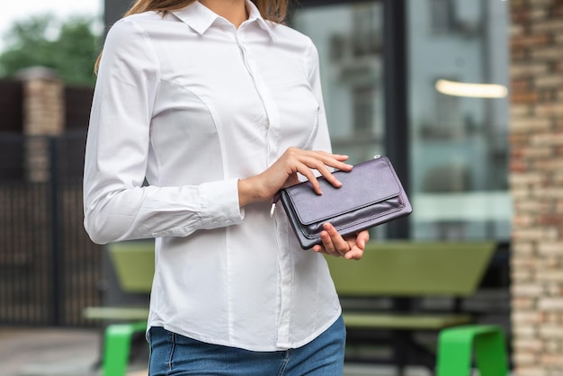 Girl in white holds a purse in her hand