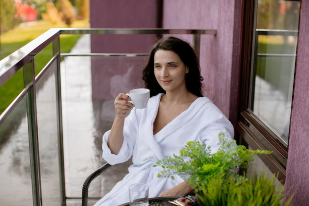 Girl in a white hotel coat in a hotel on the balcony belt
portrait