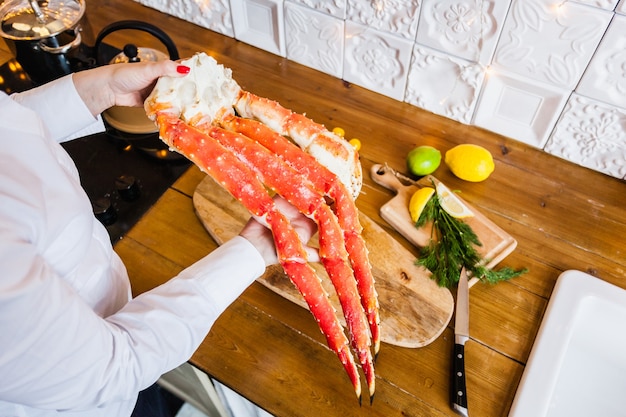 Girl in a white jacket holding a crab.