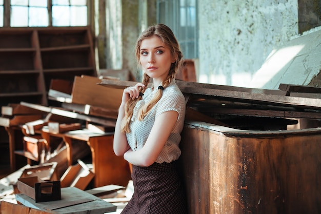 Girl in a white retro blouse in a ruined school