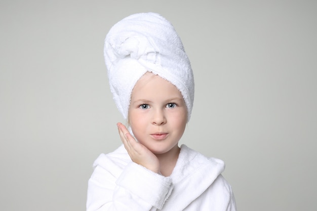 白いローブとシャワーと髪を洗った後彼女の頭にタオルの女の子