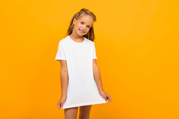 girl in a white t-shirt  on a yellow wall