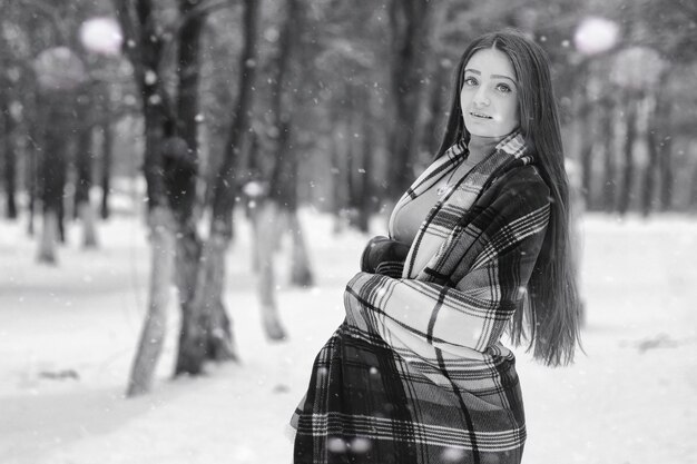 눈 덮인 들판과 숲의 겨울 흐린 날의 소녀