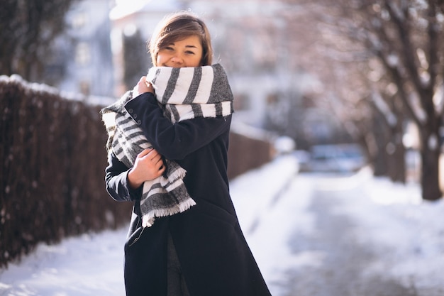 Девушка зимой покрыта шарфом в парке
