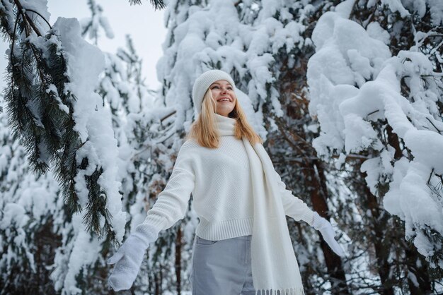 Una ragazza in una foresta d'inverno, bionda, una divertente passeggiata nella natura