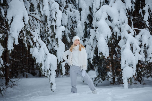 A girl in a winter forest, blonde, a fun walk in nature