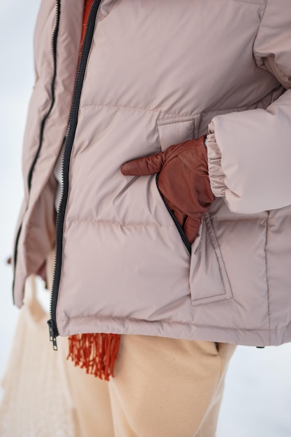 A girl in a winter jacket a hand in a camran