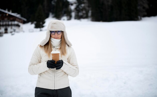 Girl in winter in light clothing holding a brown drink glass coffee tea suitable for mocap