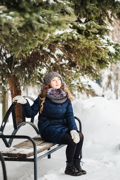 Ragazza nel parco di inverno coperto di neve