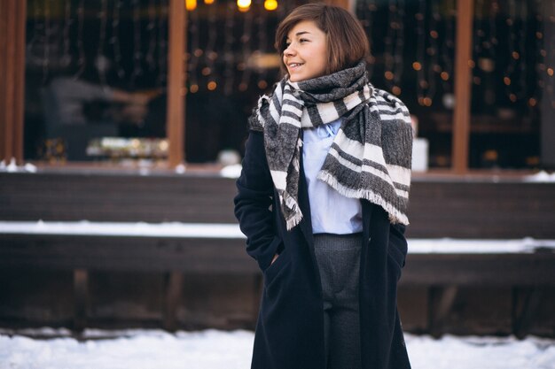 Girl in winter in scarf standing by the cafe