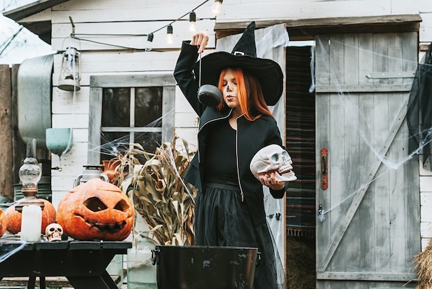 Girl in a witch costume at a Halloween party brew a potion