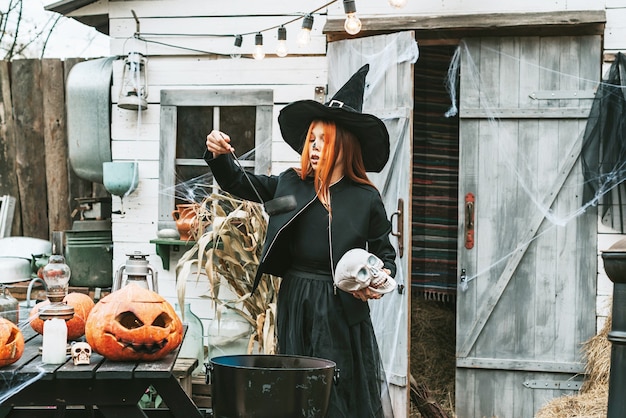 Девушка в костюме ведьмы на вечеринке в честь Хэллоуина варит зелье