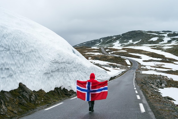 写真 ノルウェーの雪道でノルウェーの旗を持つ少女