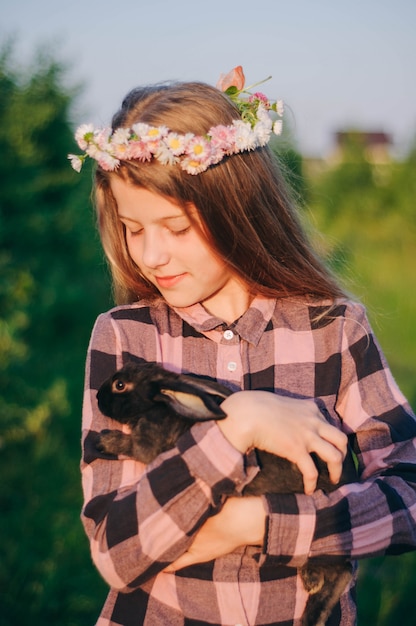 写真 彼女の手にウサギを持つ少女