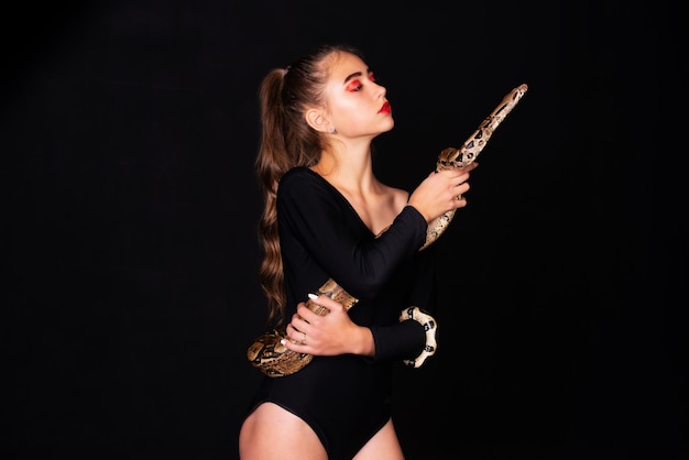 Девушка со змеей на теле на черном фоне