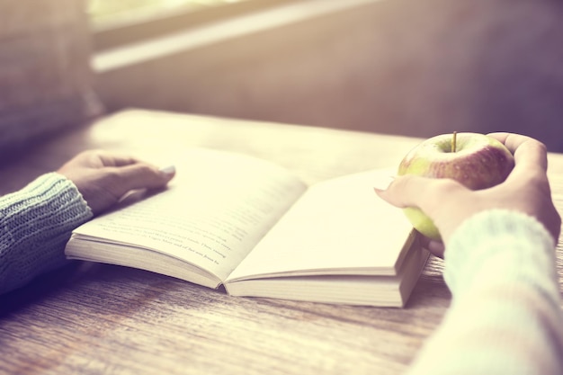 Foto ragazza con una mela e un libro