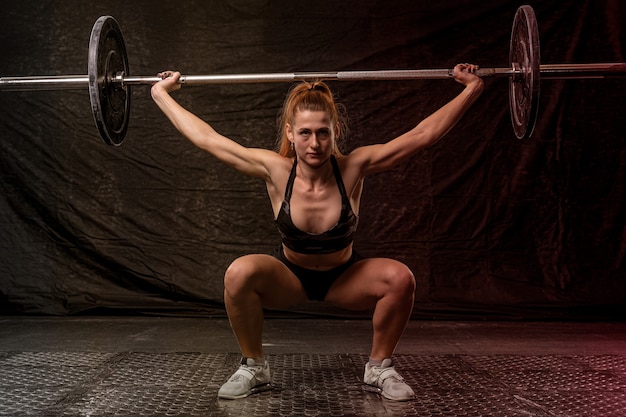 A girl with an athletic physique is engaged in crossfit