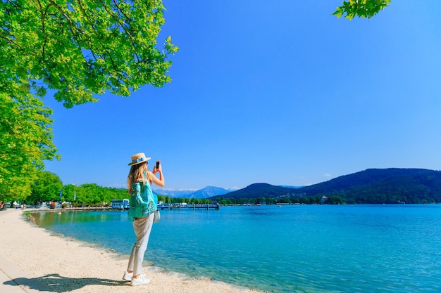 Girl with a backpack and a boater on the shore of a lake the gi