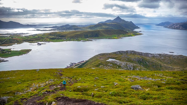 girl with backpack hiking Offersykammen trail head admiring the panorama of lofoten islands, Norway