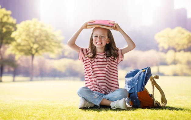 バックパックを持った女の子が学校に行きます