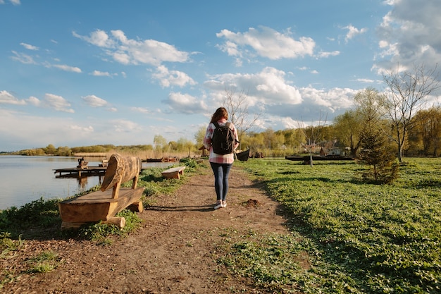 Foto ragazza con uno zaino viaggia. ragazza felice in natura