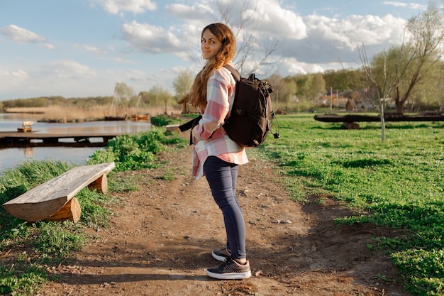 Ragazza con uno zaino viaggia. ragazza felice in natura