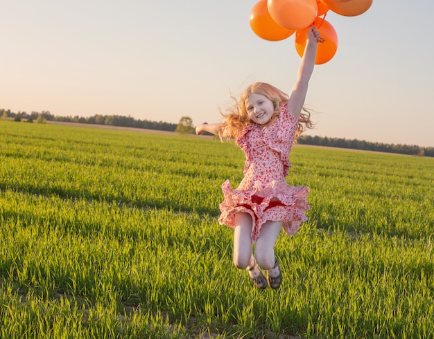 Girl with balloons jumping outdoor