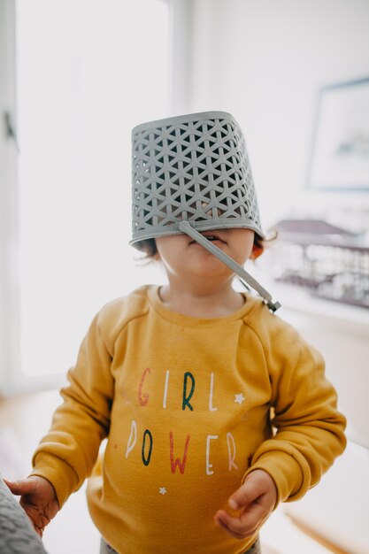 Photo girl with basket over face standing at home