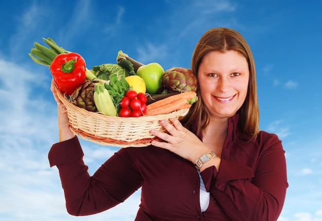 Girl with a basket full of vegetables