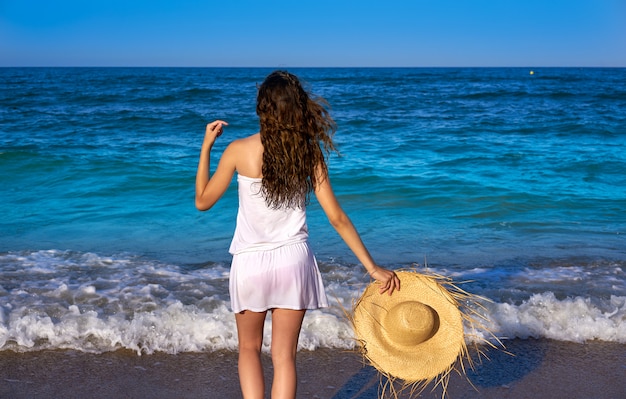 Девушка с шляпой пляжа в море летом