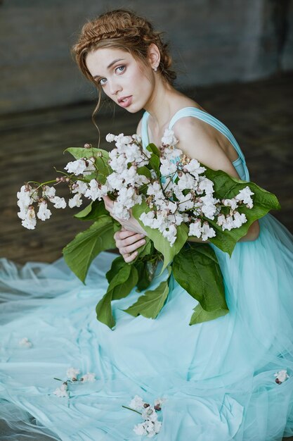 Girl with a beautiful bouquet of flowers in a blue dress