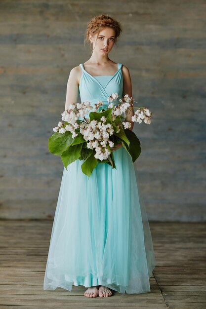 Girl with a beautiful bouquet of flowers in a blue dress