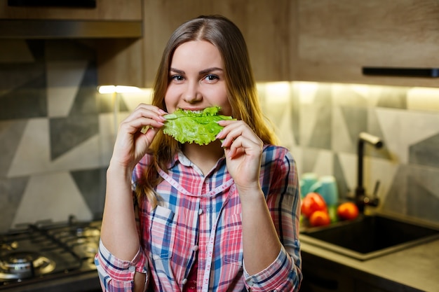 美しい姿の少女は野菜を持っています