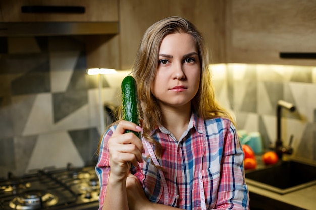 Girl with beautiful figure holds vegetables