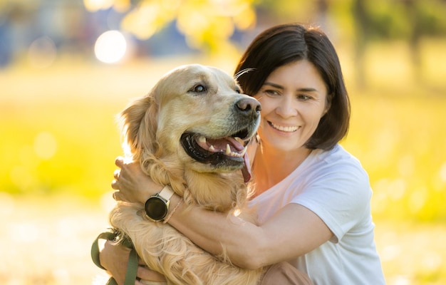 Girl with beautiful golden retriever dog portrait on a blurred background