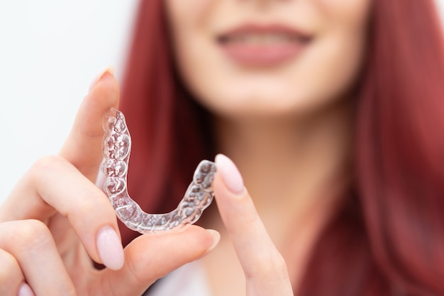 Girl with a beautiful smile shows a transparent mouth guard