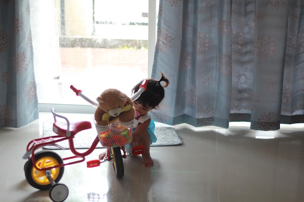 Photo girl with bicycle on floor in living room at home