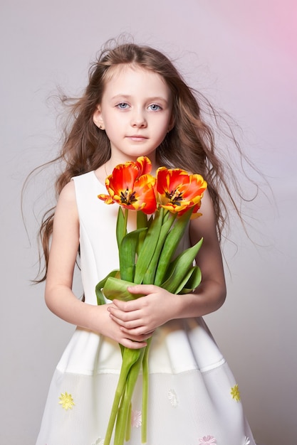 Premium Photo | Girl with big blue anime eyes and bouquet of tulip flowers  in hands. world mothers day, spring day, spring bouquet in hands of child