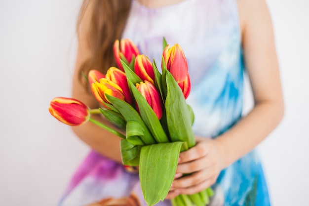 チューリップの大きな花束を持つ少女。春の花を持つ少女。