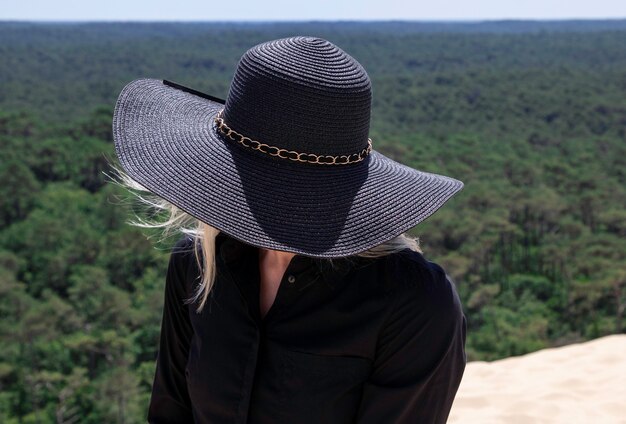 Ragazza con un grande cappello in natura