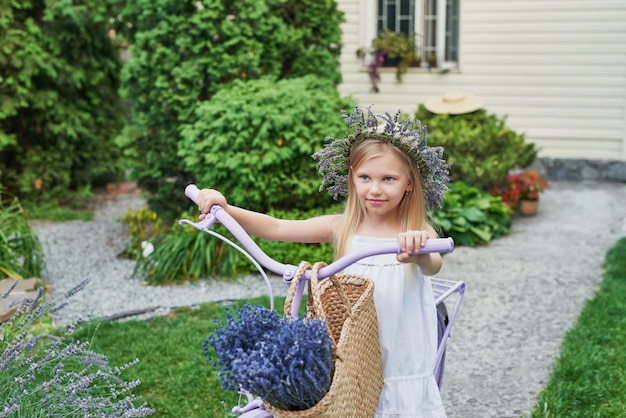 girl with bike and lavender in summer in the yard