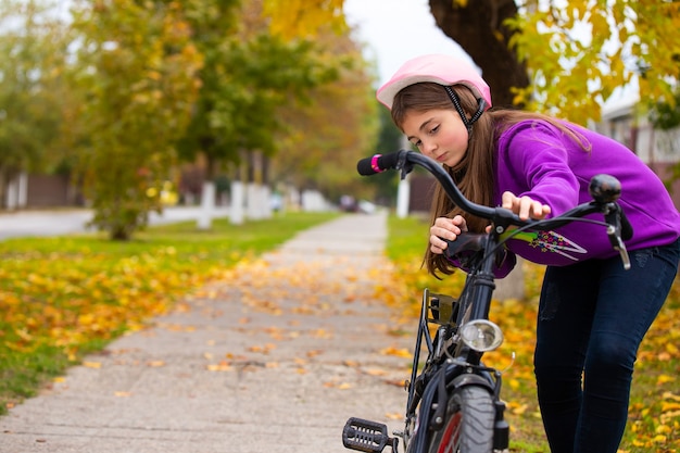 A girl with a bike in the park, resting after a bike ride. Bright colors of autumn. . 