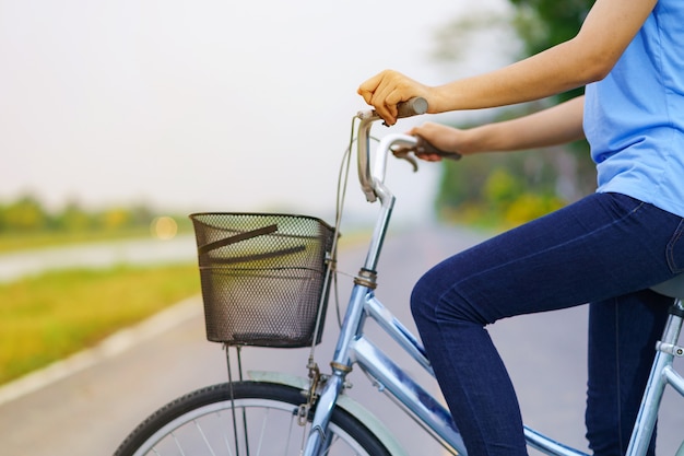 バイクの女の子、公園の道路に自転車に乗っている女性