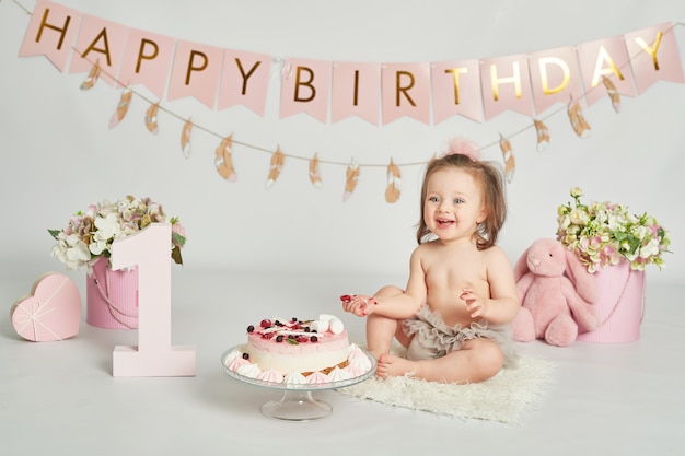 誕生日ケーキを持つ少女、1歳の赤ちゃんの写真セッション