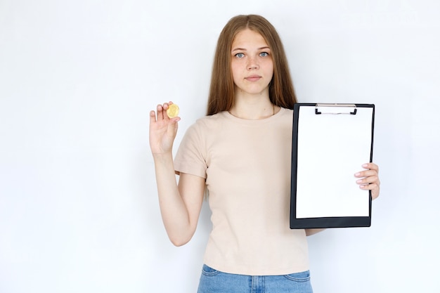 Foto ragazza con bitcoin e tablet su sfondo grigio. finanza e criptovalute
