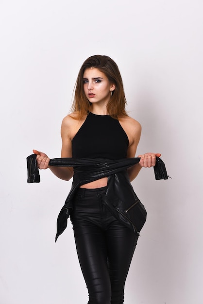 Girl with blond hair and black leather jacket on waist