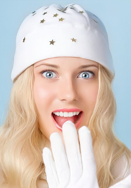 Girl with blond hair and blue eyes seems surprised and amused while smiling and enjoying the winter holiday season lifestyle