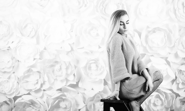 Girl with blond hair and gray sweater poses